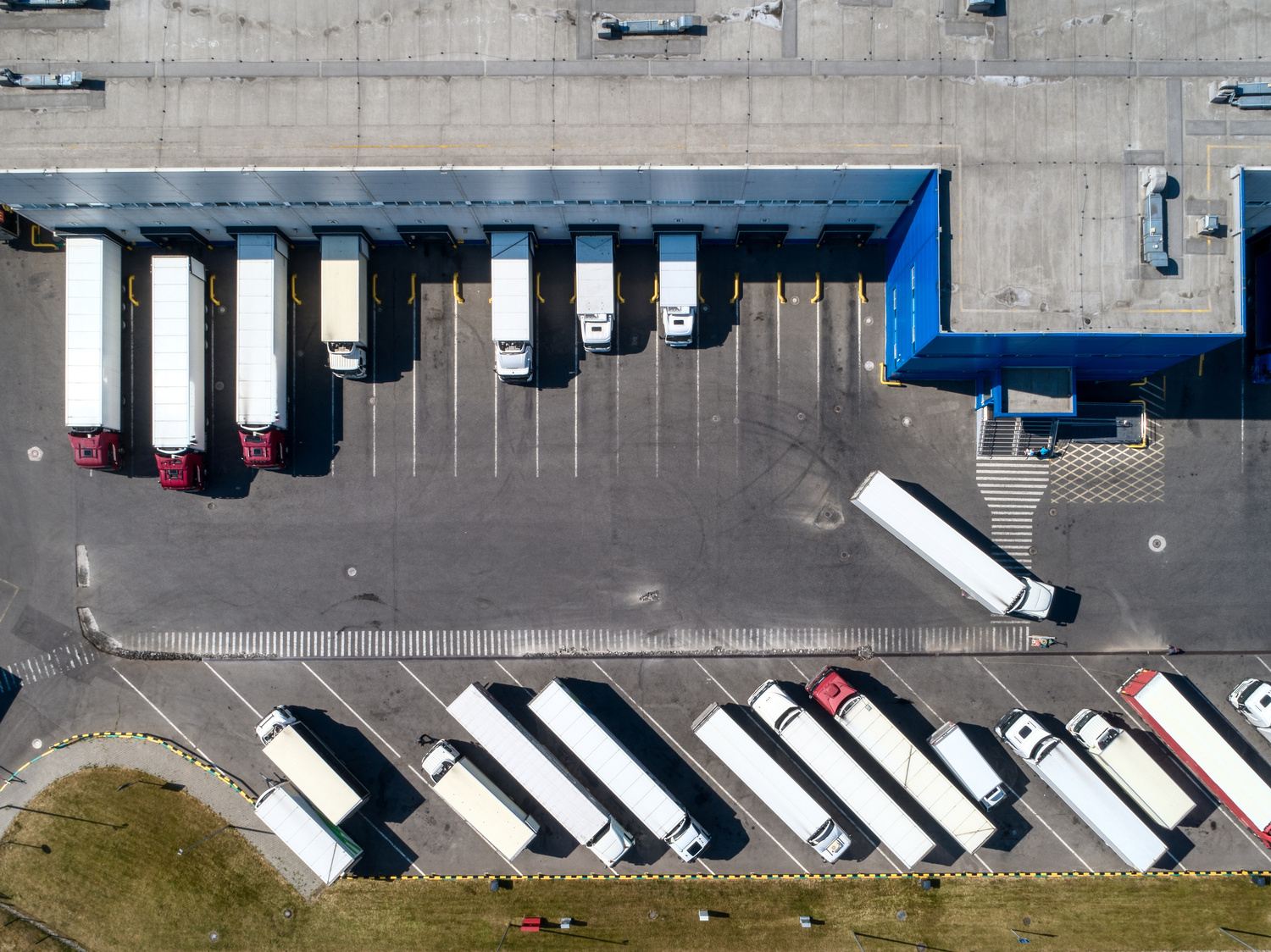 Große Lastwagen auf dem Parkplatz in der Nähe des Werkslagergebäudes